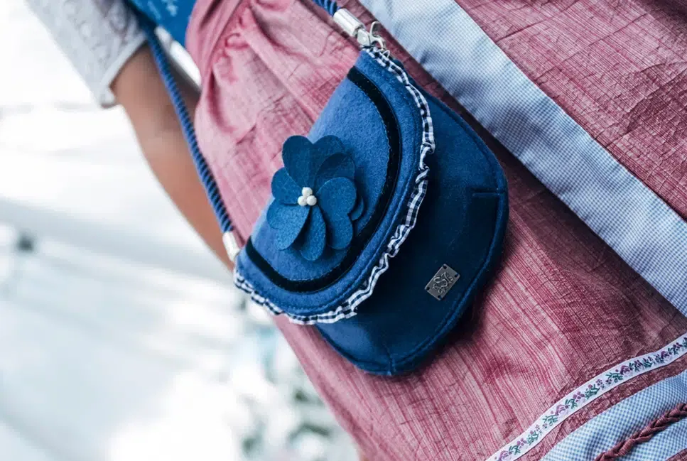 a blue purse with a flower on it