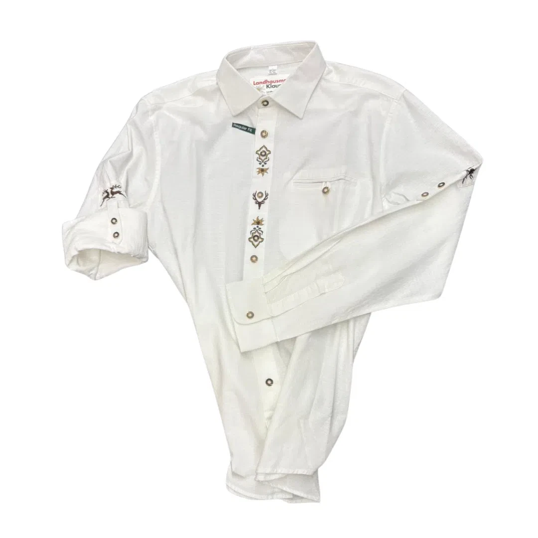 Ein langärmeliges weißes Westernhemd mit dekorativen Stickereien entlang der Knopfleiste und an den Manschetten, die auf einem einfarbig weißen Hintergrund dargestellt sind.