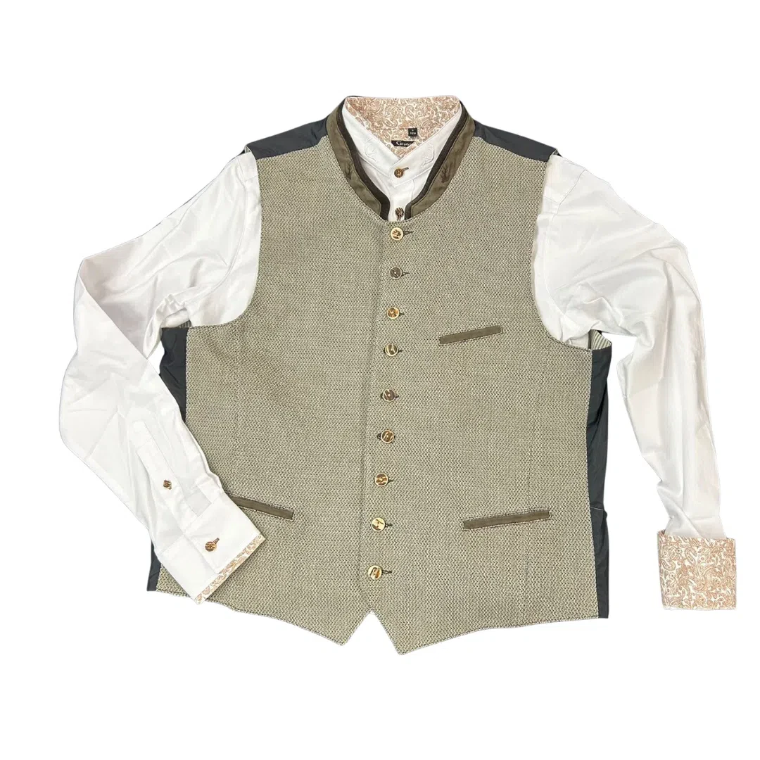 Eine traditionelle Weste über einem weißen, langärmeligen Hemd mit dekorativen, gemusterten Akzenten am Kragen und an den Manschetten, dargestellt auf weißem Hintergrund.