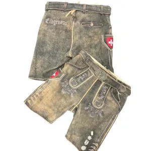 Zwei Paar traditionelle Schweizer Lederhosen mit Stickereien und Gürteldetails. Ein Paar trägt den Schriftzug Eidgenoss und beide zeigen ein rotes Schild mit einem weißen Kreuz, dem Symbol der Schweiz.